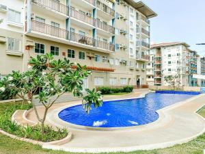an apartment with a swimming pool in front of a building at Spacious Studio in Nuvali with Wi-fi and Parking in Calamba