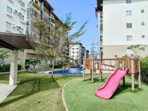 a playground in a park with a pink slide at Spacious Studio in Nuvali with Wi-fi and Parking in Calamba