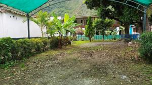 une cour avec des arbres et une maison avec une montagne dans l'établissement Casa Verde, à Quillabamba