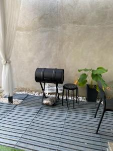 a patio with a bench and a stool next to a wall at INAP DESA ICHA, PANTAI KEMPADANG, KUANTAN PAHANG in Kuantan