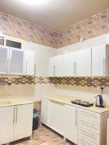 a kitchen with white cabinets and a counter top at شقة الشفاء فالي in Hail