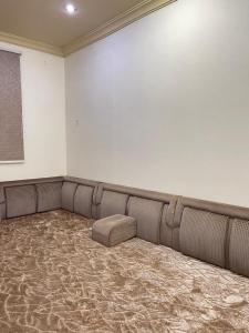 a empty waiting room with a couch in the corner at شقة الشفاء فالي in Hail