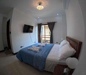 a bedroom with a large bed with a blue blanket at Angel Wish Guesthouse in El Nido