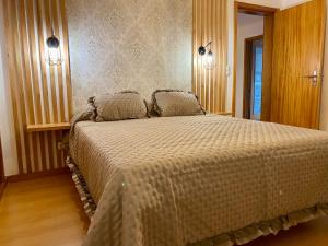 a bedroom with a large bed with two pillows at Green&Blue in Ribeira Grande