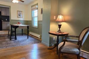 uma sala de estar com uma mesa, uma cadeira e um candeeiro em Moody Salem Home Away From Home em Salem