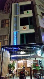 un edificio con una sombrilla delante de él en 自由塔精品民宿, en Magong
