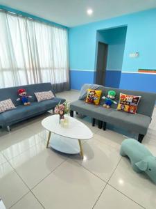 a living room with two blue couches and a table at SuperMCozy@Setapak Central Mall 10Pax 3BR 2CarPark in Kuala Lumpur