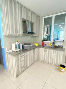 a kitchen with white cabinets and a large window at SuperMCozy@Setapak Central Mall 10Pax 3BR 2CarPark in Kuala Lumpur