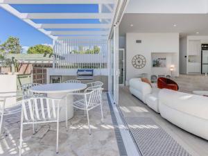 a living room with a couch and a table and chairs at Luxury Mermaid Waters Holiday Home in Gold Coast