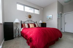 a bedroom with a bed with a red blanket at Incredible Views Beautiful 2-Bedroom Suite in Victoria