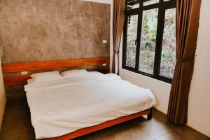 a bed in a room with a window at DC Green Resort Bavi - Resort villa complex with private pool and Mountain view in Hanoi
