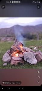 un pozo de fuego en un campo con algunas rocas en Esencia Cabaña en Potrerillos