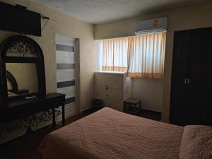 una camera d'albergo con letto, cassettiera e specchio di Hotel Regional San Marcos a Tuxtla Gutiérrez