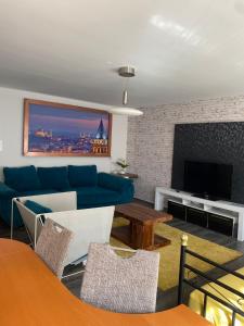 ein Wohnzimmer mit einem blauen Sofa und einem TV in der Unterkunft Apartment Düsseldorf-Süd in Düsseldorf