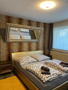 a bedroom with two beds and a mirror on the wall at Apartment Düsseldorf-Süd in Düsseldorf