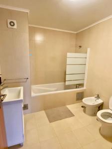 a bathroom with a tub and a toilet and a sink at Green&Blue in Ribeira Grande