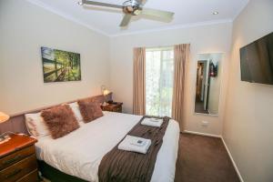 una camera con un grande letto e un ventilatore a soffitto di Silver Birches Holiday Village - Unit 7 a Bright