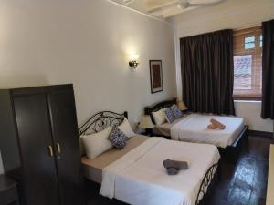 a hotel room with two beds and a window at Beach Street by Plush in George Town