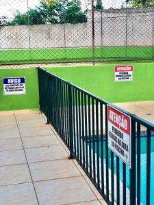 a fence with signs on the side of a baseball field at Apartamento Imp 1 - Bosque 1 in Imperatriz