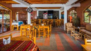 a restaurant with wooden tables and chairs at Victor Hugo Hotel in Puerto López