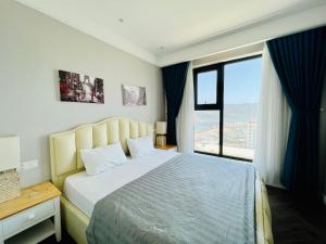 a bedroom with a large bed and a large window at ALTARA Quy Nhơn - RUBY Luxury Apartment in Quy Nhon
