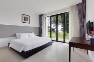 a bedroom with a bed and a desk and a window at BIỆT THỰ 3 PHÒNG NGỦ BÊN BỜ BIỂN in Ba Ria +20 photos