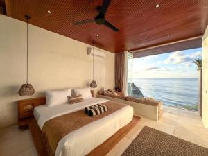 a bedroom with a large bed with a view of the ocean at Mahi Mahi Beach Shack And Suites in Uluwatu