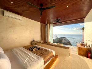 a bedroom with a bed with a view of the ocean at Mahi Mahi Beach Shack And Suites in Uluwatu
