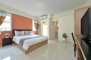 een slaapkamer met een bed en een flatscreen-tv bij Salin Home Hotel Ramkhamhaeng in Bangkok