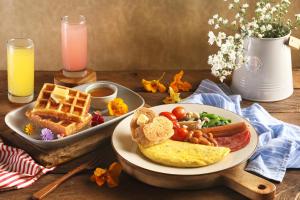 a table with a plate of breakfast foods and waffles at Dusun Bedugul Asri in Bedugul