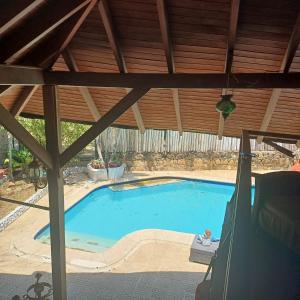 a large swimming pool under a wooden roof at LE CHALET in Barranquilla