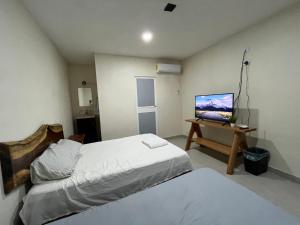 1 dormitorio con 1 cama y 1 ordenador en una mesa en Posada Ceibamar Chichen Itzá en Pisté