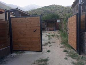 een open poort in een tuin met bergen op de achtergrond bij Hermosa casa - Cajon del Maipo in El Canelo