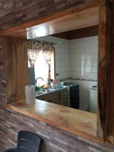 een keuken met een aanrecht met een spiegel bij Hermosa casa - Cajon del Maipo in El Canelo
