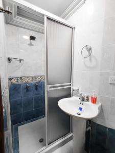a bathroom with a sink and a shower at Hotel Miluansa in Pereira