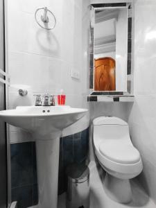 a white bathroom with a sink and a toilet at Hotel Miluansa in Pereira