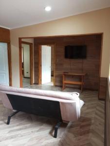 een kamer met een bed en een televisie en een tafel bij Hermosa casa - Cajon del Maipo in El Canelo