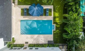 an overhead view of a swimming pool with a blue umbrella at The Sapphire Villa - LUX 5 Bed in West Palm Beach