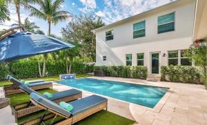a swimming pool in front of a house at The Sapphire Villa - LUX 5 Bed in West Palm Beach