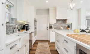 a white kitchen with white cabinets and a counter at The Sapphire Villa - LUX 5 Bed in West Palm Beach +39 photos