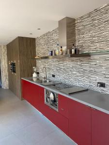 Loft في أنتويرب: مطبخ مع دواليب حمراء ومغسلة