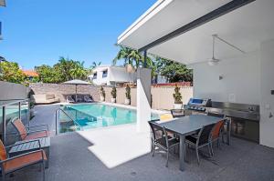 a patio with a table and chairs next to a pool at Silver Sea on Sixth Resort in Maroochydore