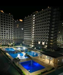 a view of a hotel with two pools at night at SAEKYUNG CoNDo HoMESTaY in Lapu Lapu City