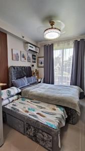 a bedroom with two beds and a chandelier at SAEKYUNG CoNDo HoMESTaY in Lapu Lapu City +21 photos