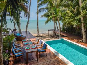 a table and chairs on a deck next to a swimming pool at Private Beach House @ Hin Kong Beach in Hinkong