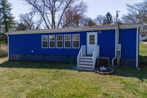 una casa azul con una escalera en un patio en Blue Ridge Haven: Close to Everything!, en Asheville