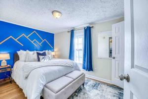 1 dormitorio con 1 cama con pared azul en Blue Ridge Haven: Close to Everything!, en Asheville