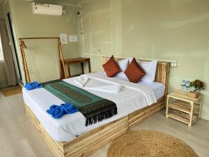1 dormitorio con 1 cama grande con almohadas azules en Naroth Beach Bungalow, en Koh Rong