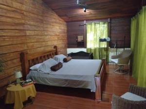 FINCA La PAZ - Sarapiqui في Puerto Viejo: غرفة نوم مع سرير مع دمية دب عليها