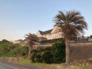 a house with palm trees on the side of a road at sunset hills - Vacation STAY 21373v in Hamada